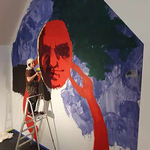 Sharpe paints mural at  her exhibition 'Ghosts'